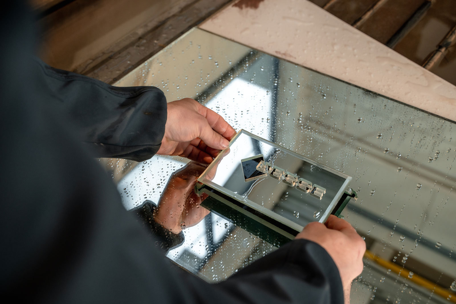 Un employé retire délicatement une pièce découpé au waterjet